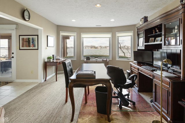 office space featuring baseboards, plenty of natural light, a textured ceiling, and light tile patterned flooring