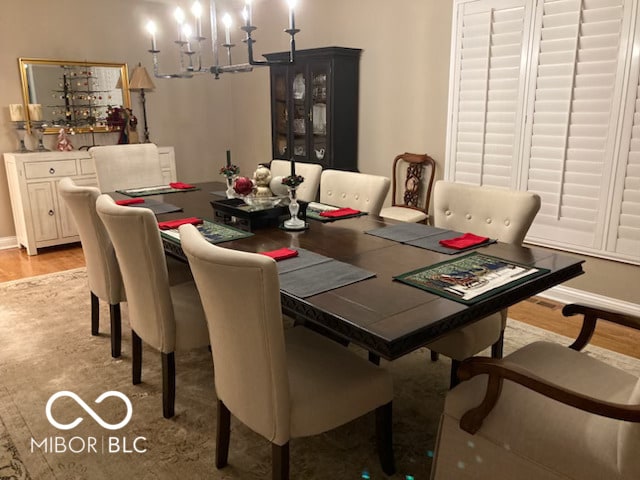 dining space with a chandelier, light wood-style flooring, and baseboards