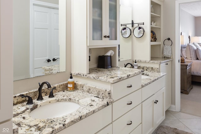 ensuite bathroom featuring tile patterned floors, connected bathroom, and vanity