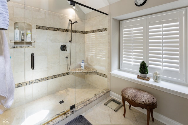 bathroom with tile patterned floors, baseboards, a stall shower, and vaulted ceiling