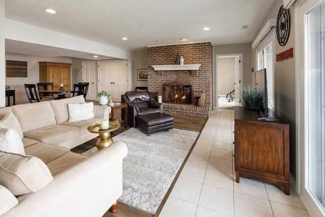 living room featuring visible vents, a textured ceiling, recessed lighting, light tile patterned flooring, and a fireplace