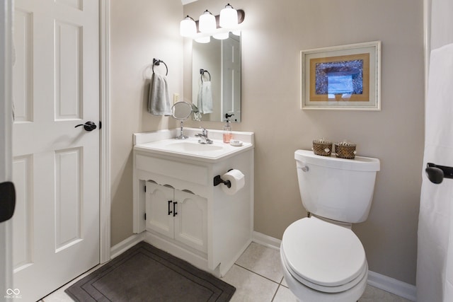 bathroom with tile patterned flooring, toilet, vanity, and baseboards