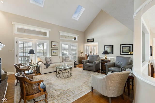 living room featuring a skylight, wood finished floors, and high vaulted ceiling