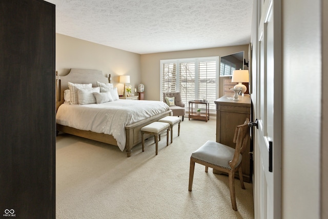 bedroom with light carpet and a textured ceiling