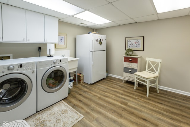 laundry area with visible vents, cabinet space, light wood-style floors, baseboards, and washing machine and clothes dryer