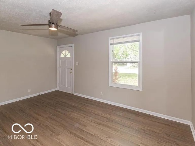 entryway with a ceiling fan, wood finished floors, baseboards, and a textured ceiling