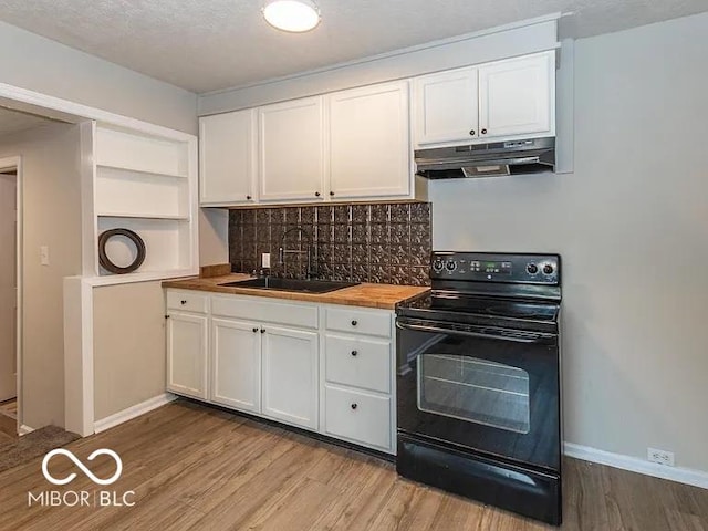 kitchen with a sink, black / electric stove, under cabinet range hood, and white cabinets