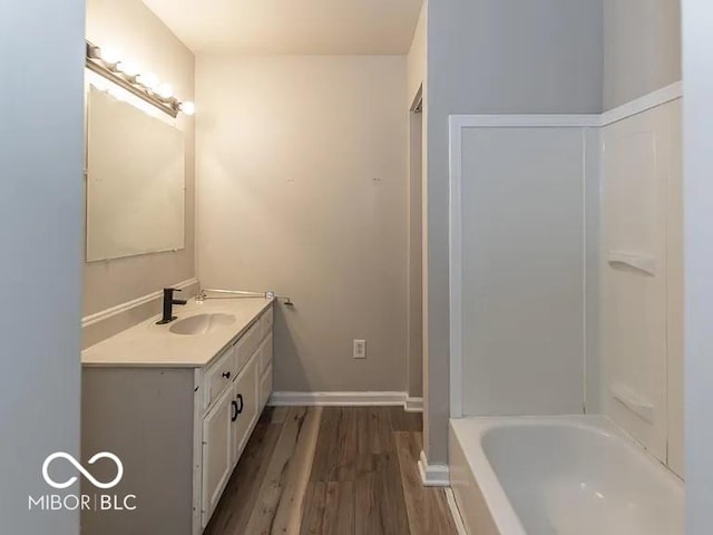 full bathroom with vanity, baseboards, and wood finished floors