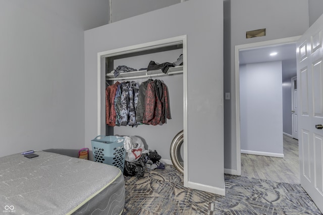 bedroom featuring wood finished floors, baseboards, and a closet