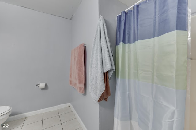 full bathroom featuring a shower with curtain, tile patterned floors, toilet, and baseboards