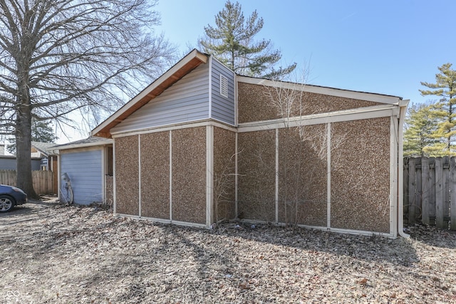 view of outbuilding featuring fence