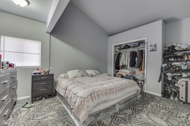 bedroom with lofted ceiling, baseboards, and a closet