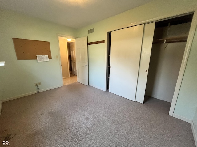 unfurnished bedroom featuring carpet flooring, baseboards, visible vents, and a closet