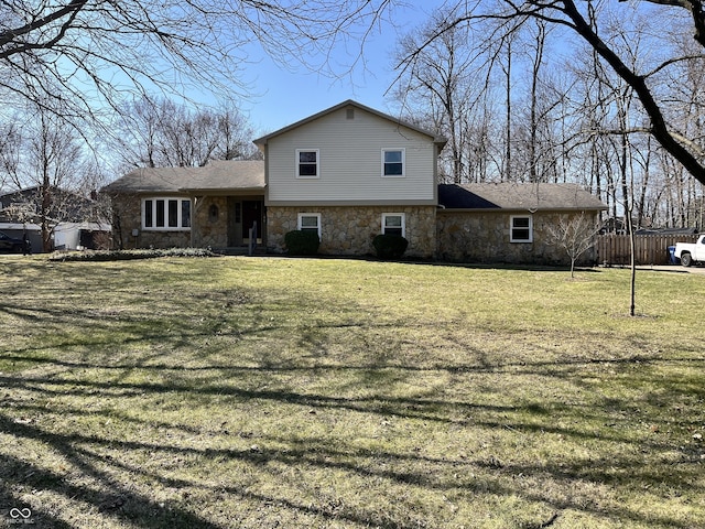 exterior space with stone siding, a lawn, and fence