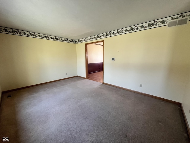 unfurnished room featuring carpet, visible vents, and baseboards