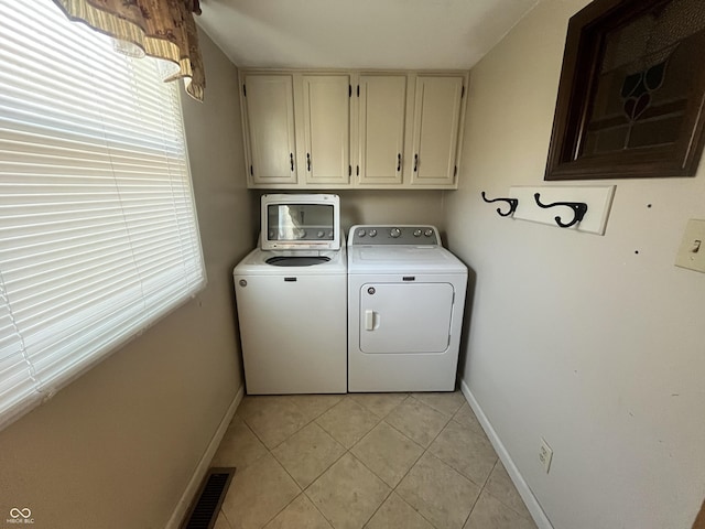 clothes washing area featuring light tile patterned floors, baseboards, visible vents, washing machine and clothes dryer, and cabinet space