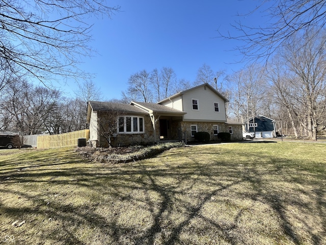 exterior space with stone siding, a front lawn, and fence