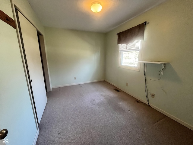 unfurnished bedroom with carpet, baseboards, and a closet