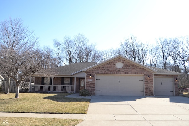 single story home with driveway, covered porch, a front yard, a garage, and brick siding