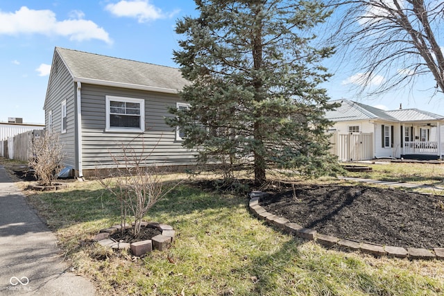 view of front of house featuring roof with shingles and fence