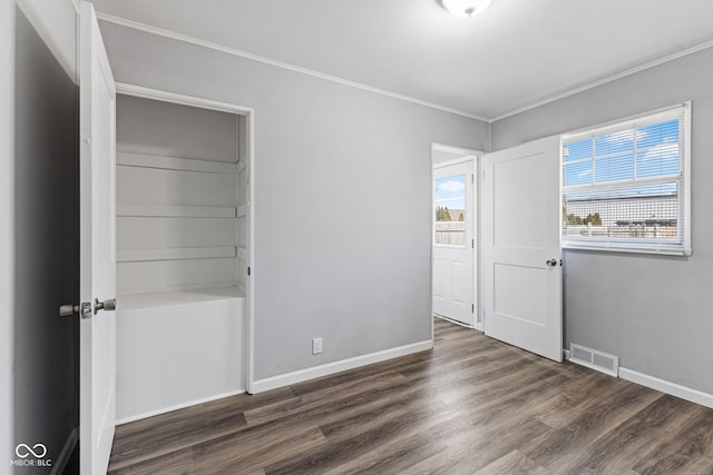 unfurnished bedroom featuring visible vents, crown molding, baseboards, and wood finished floors