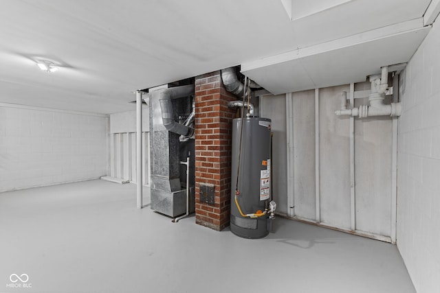 finished basement featuring heating unit, gas water heater, and concrete block wall