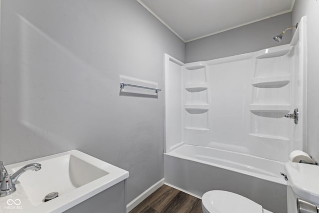 bathroom featuring wood finished floors, baseboards, ornamental molding, bathtub / shower combination, and toilet