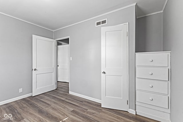 unfurnished bedroom with crown molding, wood finished floors, baseboards, and visible vents