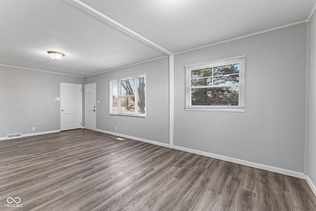 spare room with wood finished floors, baseboards, visible vents, and ornamental molding