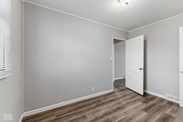 unfurnished bedroom featuring visible vents, baseboards, wood finished floors, and ornamental molding