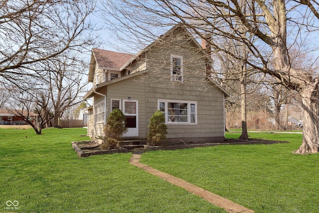 view of front of property featuring roof with shingles and a front lawn