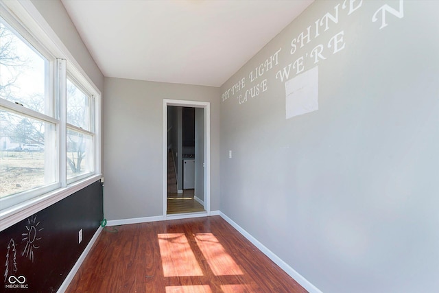 empty room with dark wood-style floors and baseboards