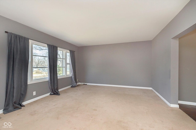 unfurnished room featuring carpet flooring and baseboards