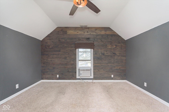 carpeted spare room featuring visible vents, lofted ceiling, baseboards, and ceiling fan