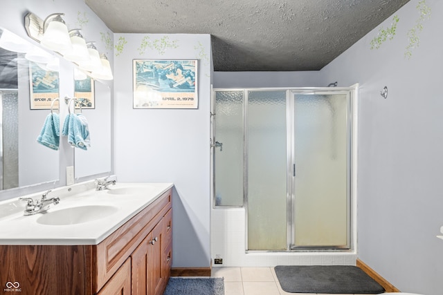 full bath featuring a sink, a textured ceiling, a stall shower, and tile patterned flooring