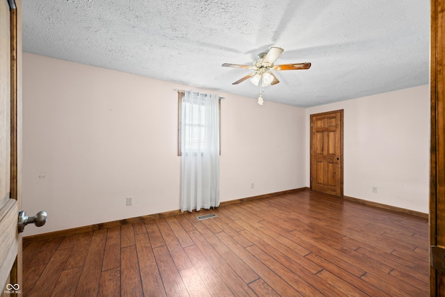 unfurnished room featuring hardwood / wood-style flooring, visible vents, and a textured ceiling