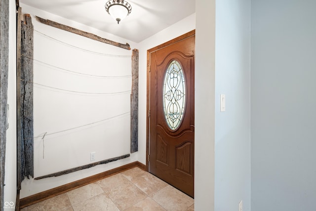 foyer entrance with light tile patterned floors and baseboards