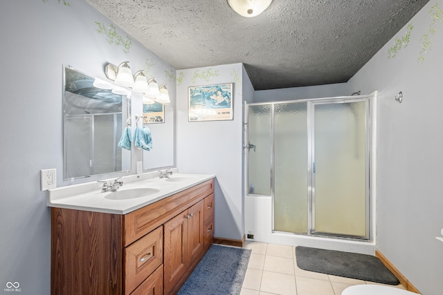 full bath featuring a sink, a shower with door, a textured ceiling, and tile patterned flooring