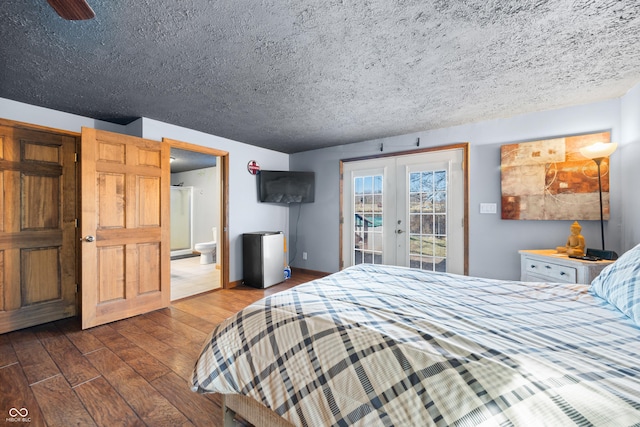 bedroom featuring ensuite bath, access to exterior, dark wood-type flooring, french doors, and a textured ceiling