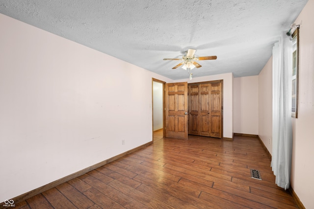 unfurnished bedroom with visible vents, baseboards, and wood-type flooring