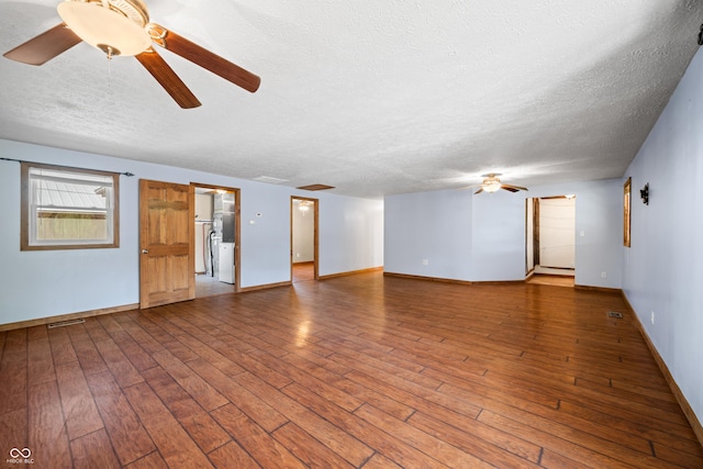 unfurnished living room with a textured ceiling, hardwood / wood-style flooring, baseboards, and ceiling fan