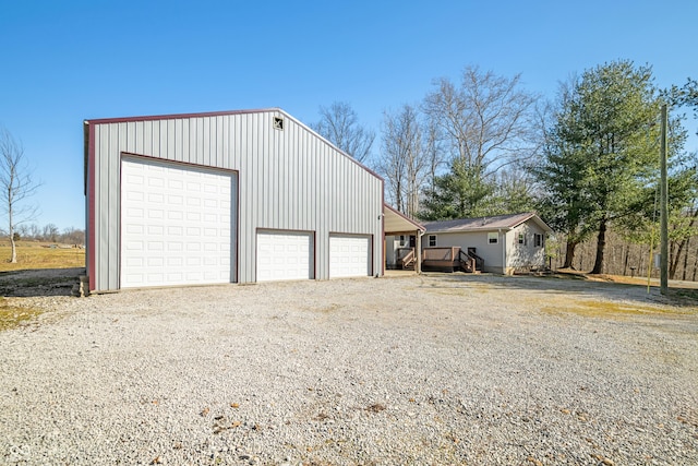 detached garage with gravel driveway