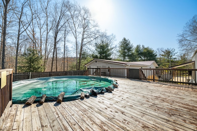 view of swimming pool with a wooden deck, a fenced in pool, and a fenced backyard