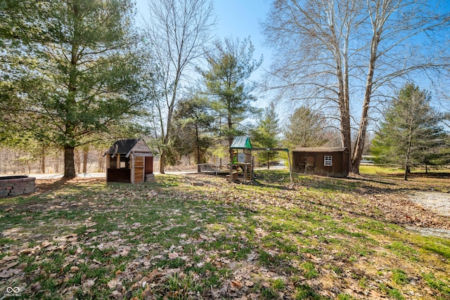 view of yard featuring an outbuilding, a shed, and a playground