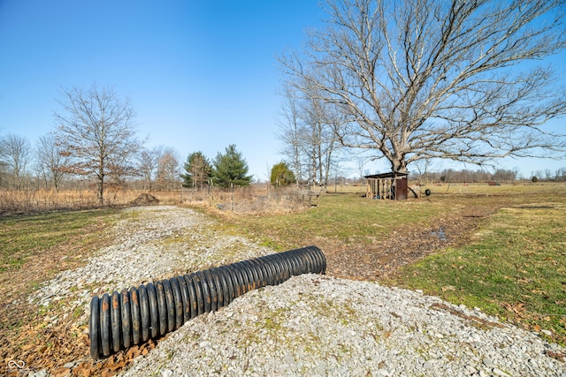 view of yard with an outdoor structure, a rural view, and a shed