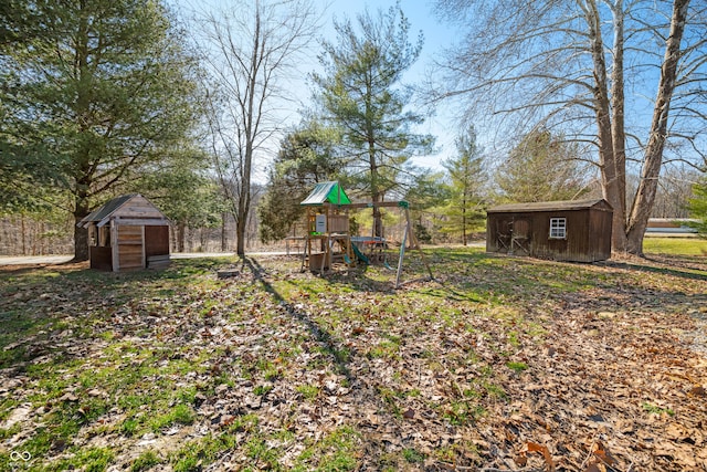 view of yard with a playground, an outbuilding, and a shed