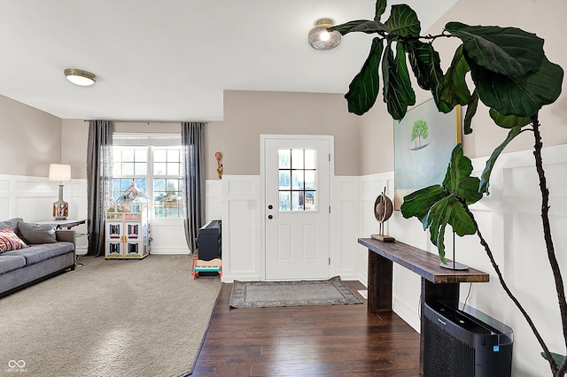 entryway featuring a decorative wall, wood finished floors, and wainscoting