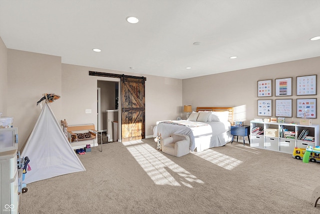 carpeted bedroom with recessed lighting and a barn door