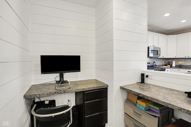 kitchen with stainless steel microwave, tasteful backsplash, recessed lighting, white cabinets, and stove