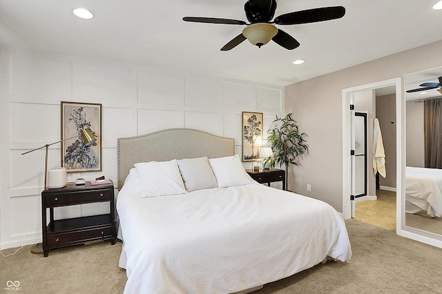 carpeted bedroom with a ceiling fan, a decorative wall, and recessed lighting